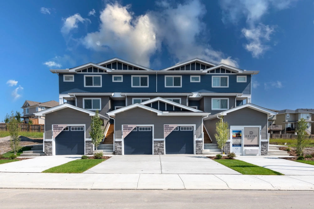 The completed townhome block on Heritage Circle - four attached units with stone-clad double garages.