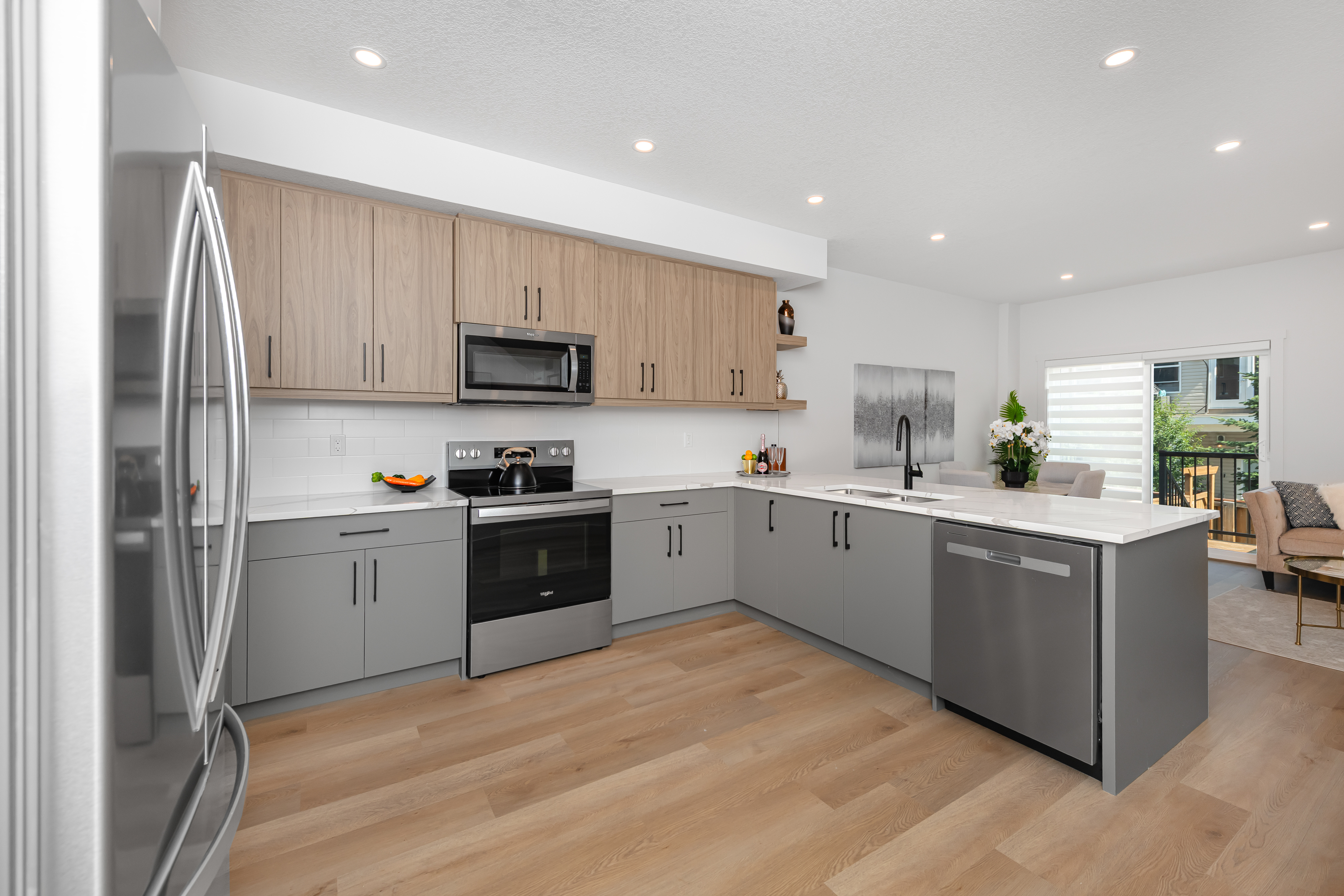 The Cardston at 146 Heritage Circle - kitchen with two-tone cabinetry and quartz counters.
