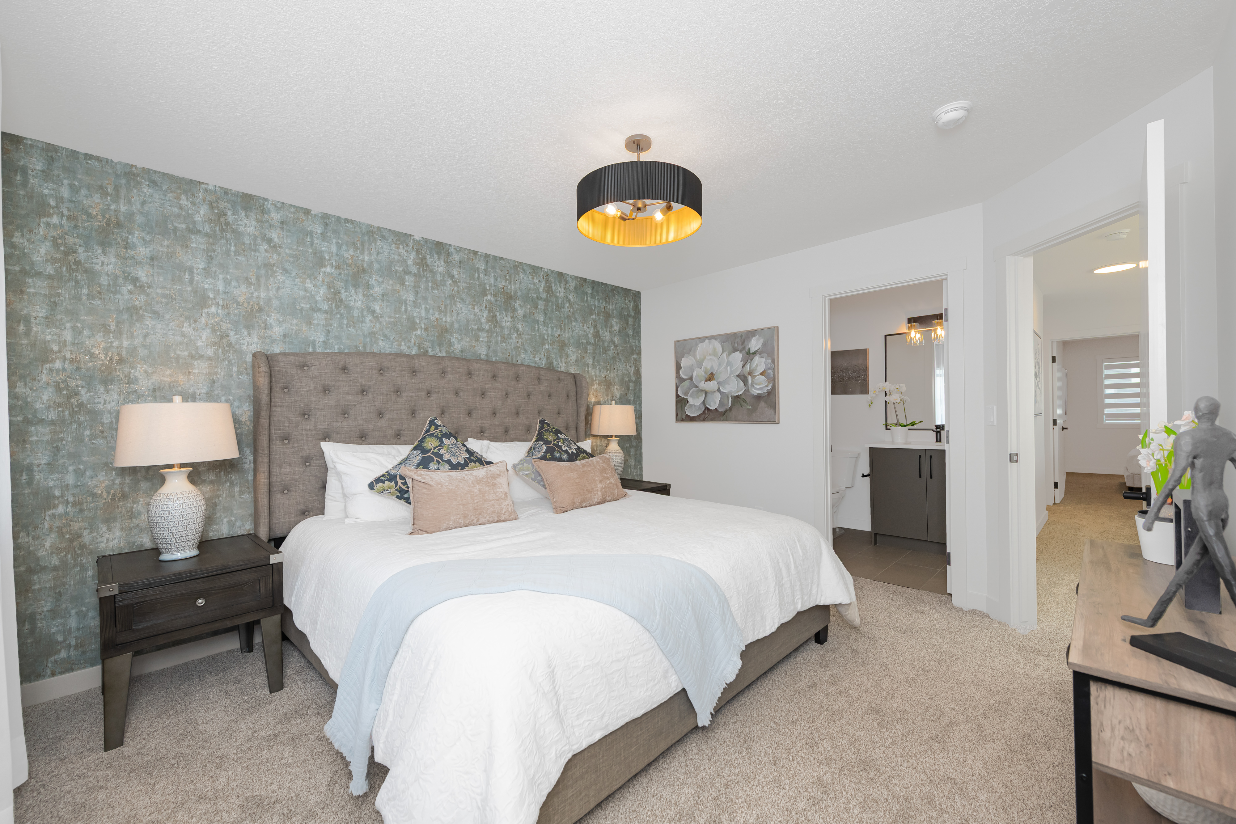 Primary bedroom with a textured feature wall.