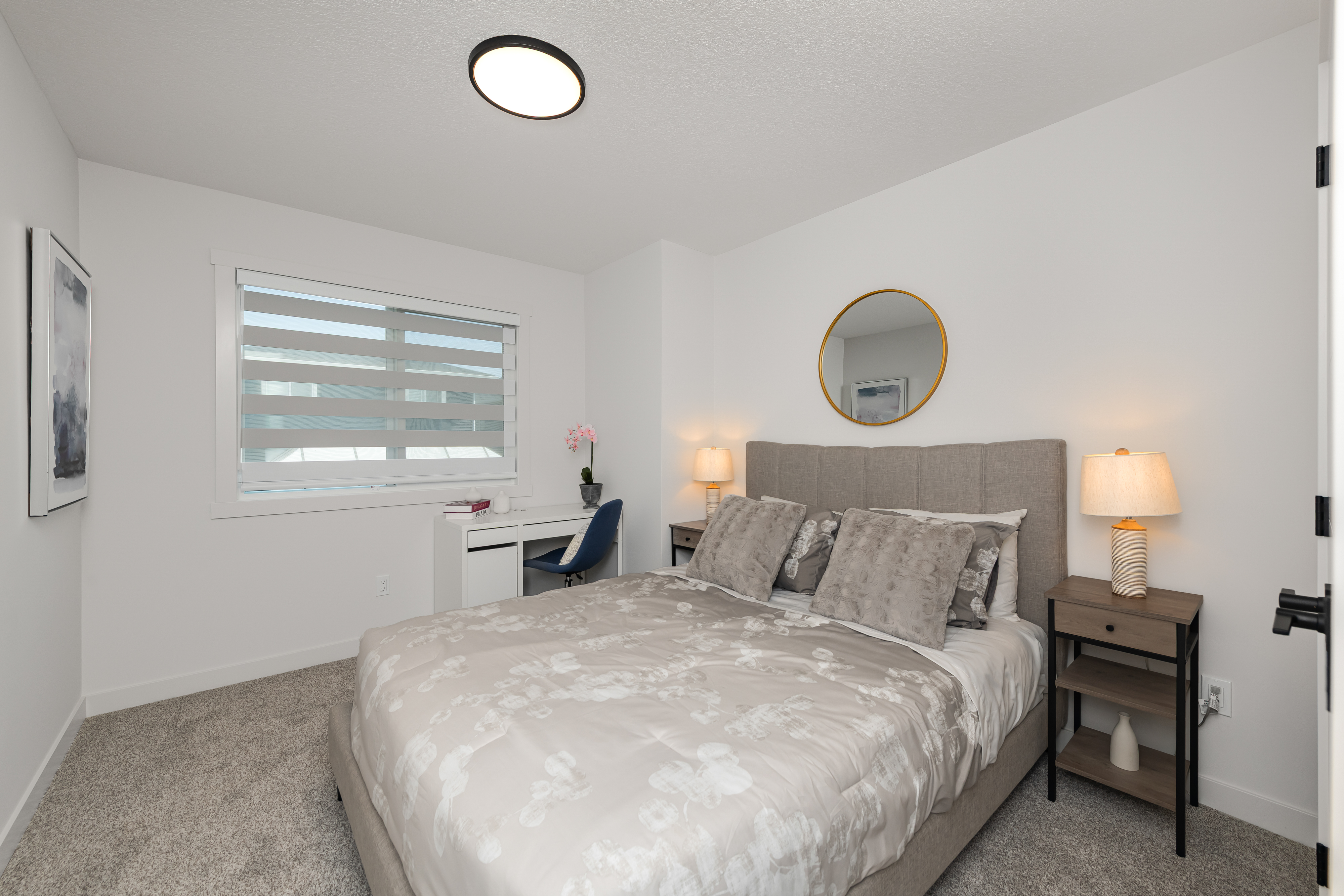 The Cardston at 178 Heritage Circle - bedroom with a queen bed and desk.